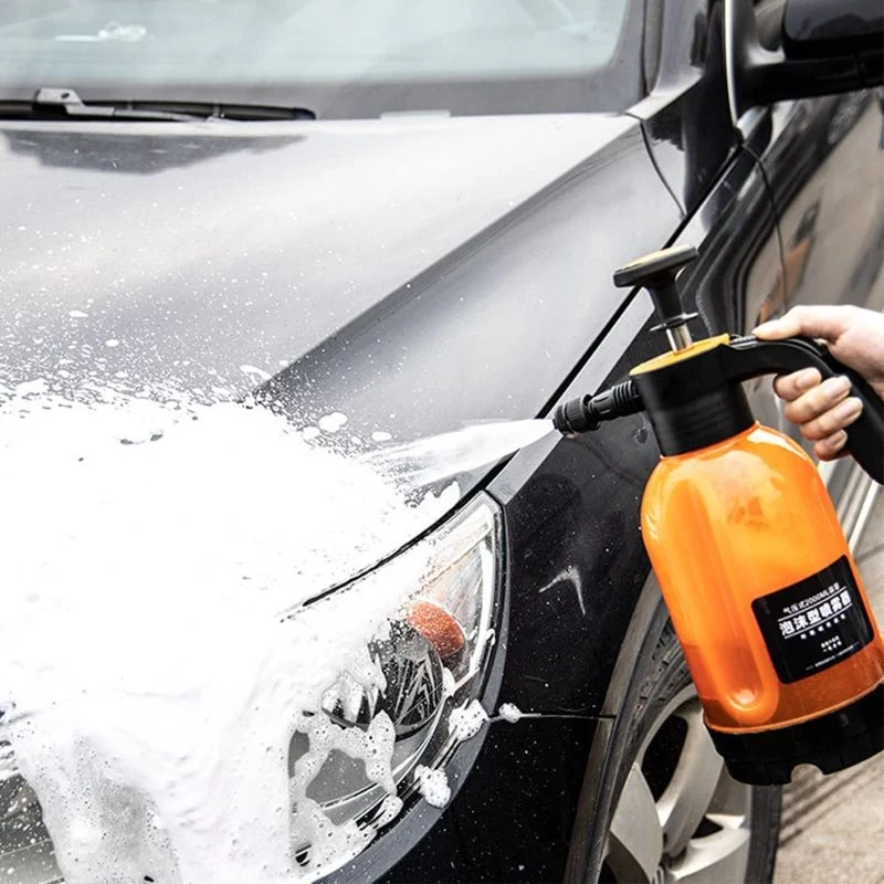 Pulverizador de espuma aplicando espuma de lavagem sobre o capô de um carro